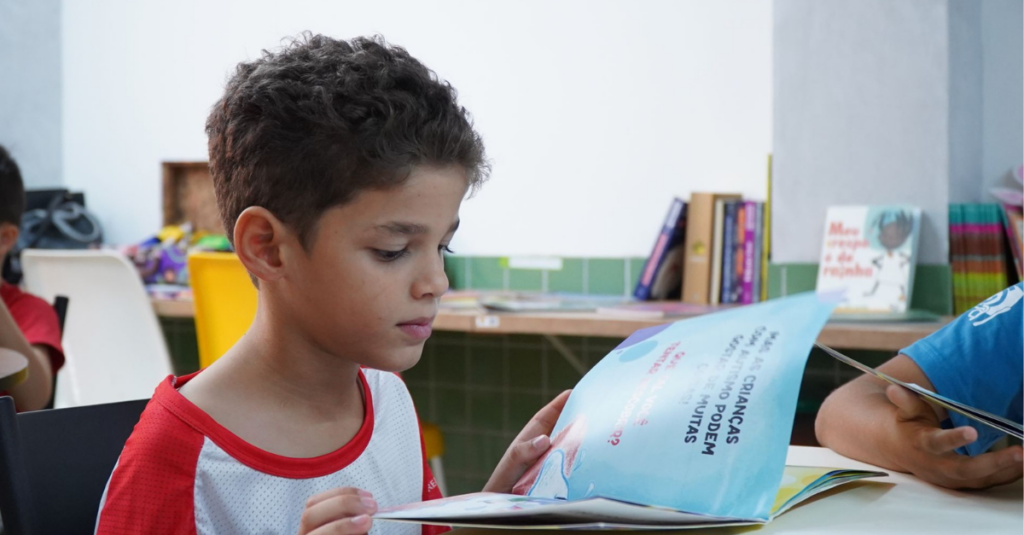 menino olhando para livro na escola
